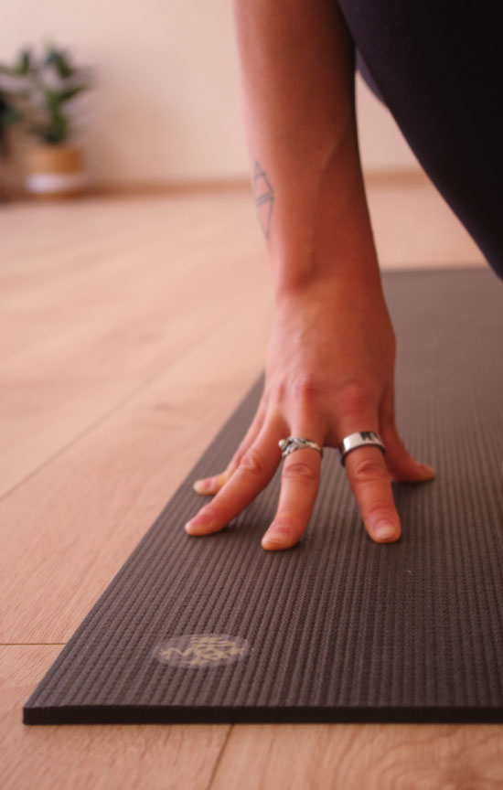 dettaglio della mano appoggiata sul tappetino durante una pratica di yoga